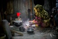 A woman is cooking rice balls on a traditional charcoal-burning clay stove at Narsingdi Royalty Free Stock Photo