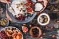 Woman cooking Rice coconut porridge with figs, berries, nuts and coconut milk in plate