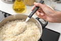 Woman cooking rice on stove in kitchen, closeup Royalty Free Stock Photo