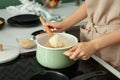 Woman cooking rice on stove in kitchen, closeup Royalty Free Stock Photo