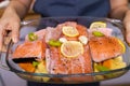 woman cooking salmon fish with vegetables in baking dish in oven at home kitchen Royalty Free Stock Photo