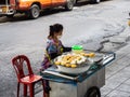 Lady with face mask cooking delicious rice balls along the street in Bangkok, Thailand Royalty Free Stock Photo