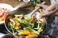 Woman cooking stir fried vegetables