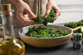 Woman cooking tasty kale salad on grey table Royalty Free Stock Photo