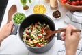 Woman cooking tasty rice with vegetables in saucepan Royalty Free Stock Photo