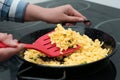 Woman cooking tasty scrambled eggs in wok pan on stove Royalty Free Stock Photo