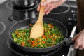 Woman cooking tasty vegetable mix in frying pan at home, closeup Royalty Free Stock Photo