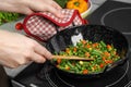 Woman cooking tasty vegetable mix in wok pan at home, closeup Royalty Free Stock Photo