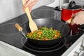 Woman cooking tasty vegetable mix in wok pan at home, closeup Royalty Free Stock Photo