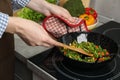 Woman cooking tasty vegetable mix in wok pan at home Royalty Free Stock Photo