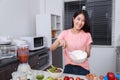 Woman cooking and whisking eggs in a bowl in kitchen Royalty Free Stock Photo