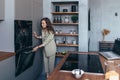 Woman cooks food in the oven and peeks to see if it is ready. Royalty Free Stock Photo