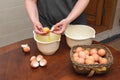 Woman cooks in the kitchen: separating proteins from yolks, breaking eggs for making dough - food photo Royalty Free Stock Photo