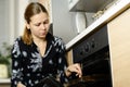 Woman cooks potatoes in the oven