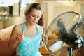 Woman cooling down using fan suffering from summer heat