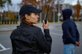 Woman cop using portable radio back view