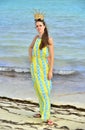 Woman with a coral crown on her head on a sand coast of the ocean. Royalty Free Stock Photo