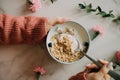 Woman in coral woolen sweater eating breakfast bowl