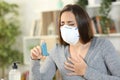 Woman with coronavirus symptoms holding inhaler at home Royalty Free Stock Photo