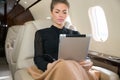 Woman in corporate jet looking at tablet computer Royalty Free Stock Photo