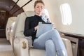Woman in corporate jet looking at tablet computer Royalty Free Stock Photo
