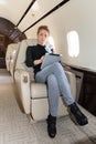 Woman in corporate jet looking at tablet computer Royalty Free Stock Photo