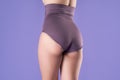 Woman in corrective panties, female body in shapewear on purple background