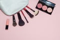 Woman cosmetic bag, make up beauty products on pink background. Makeup brushes, pink lipstick and rouge palettes. Decorative cosme Royalty Free Stock Photo