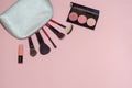 Woman cosmetic bag, make up beauty products on pink background. Makeup brushes, pink lipstick and rouge palettes. Decorative cosme Royalty Free Stock Photo