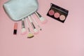 Woman cosmetic bag, make up beauty products on pink background. Makeup brushes, pink lipstick and rouge palettes. Decorative cosme Royalty Free Stock Photo