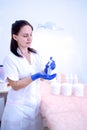 Woman cosmetician in gloves and with cream