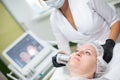 A woman in a cosmetology office receives a SMAS lifting procedure. Non-surgical ultrasound facelift, rejuvenation