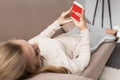 woman on couch using smartphone with youtube app