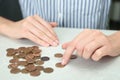 Woman counting coins at light table Royalty Free Stock Photo