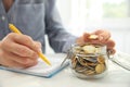 Woman counting coins at table, closeup. Savings concept Royalty Free Stock Photo