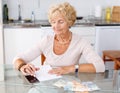 Woman counting her expenses using smartphone Royalty Free Stock Photo