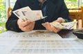 Woman is counting money with statement paper financial concept. Royalty Free Stock Photo