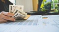 Woman is counting money with statement paper financial concept. Royalty Free Stock Photo