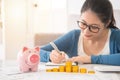 Woman counting and recording her savings Royalty Free Stock Photo