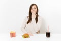 Woman cover mouth with hand at table with burger, french fries, cola in glass bottle isolated on white background Royalty Free Stock Photo