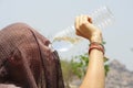 Woman with covered head drinking water from a plastic bottle Royalty Free Stock Photo