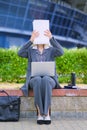 The woman covered her face with the paper. The businesswoman hid behind the paperwork. Concept.