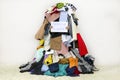 Woman covered with pile of different cloth holding Nothing to wear table sign