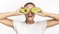 Woman Covering Eyes With Avocado Halves Having Fun In Studio