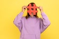 Woman covering face with social media hashtag symbol, recommending to follow trendy content.