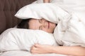 Woman covering head with pillow because of noise Royalty Free Stock Photo