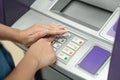 Woman covering her hands whilst entering her PIN at an ATM Royalty Free Stock Photo