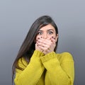 Woman covering her mouth with hands against  gray background Royalty Free Stock Photo