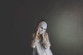 woman covers her face with a mask to protect herself  concept of loneliness and introspection Royalty Free Stock Photo