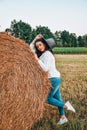 Woman in cowboy hat staying near a straw bale. Summer, beauty, fashion, glamour, lifestyle concept. Cottagecore farmcore Royalty Free Stock Photo